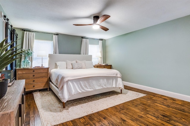 bedroom with ceiling fan, dark hardwood / wood-style floors, and a textured ceiling