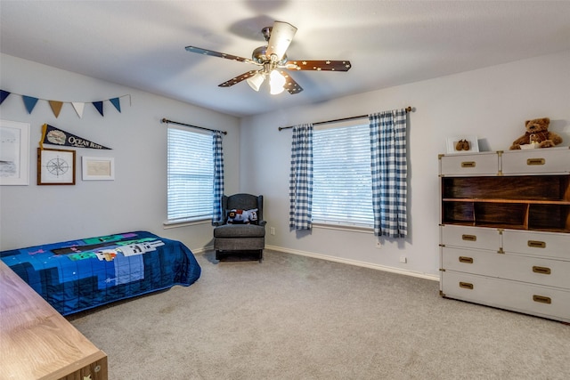 bedroom featuring ceiling fan, light colored carpet, and multiple windows