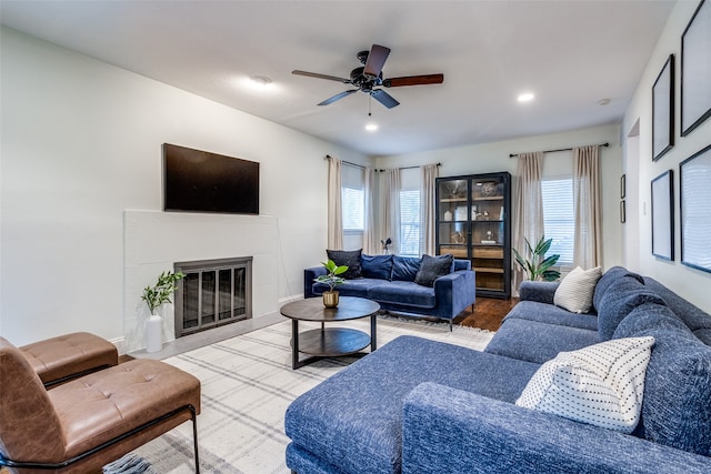 living room featuring ceiling fan and a tile fireplace