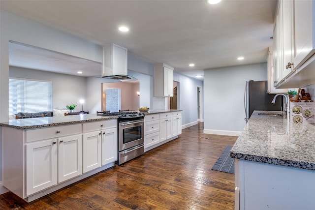 kitchen featuring sink, stainless steel gas stove, island range hood, dark hardwood / wood-style flooring, and white cabinets