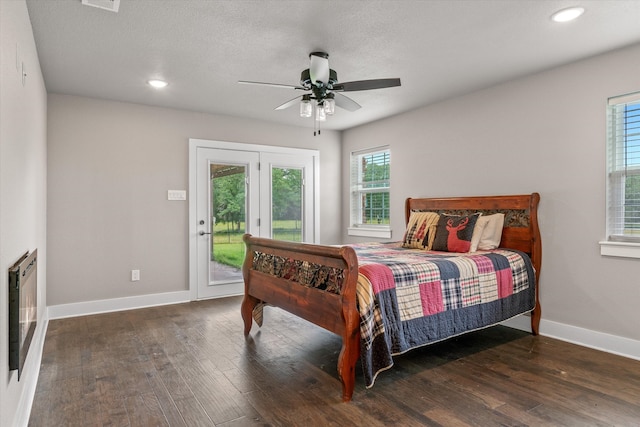 bedroom with access to outside, ceiling fan, a textured ceiling, dark hardwood / wood-style flooring, and heating unit