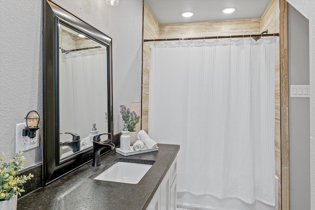 bathroom featuring shower / bath combo with shower curtain and vanity