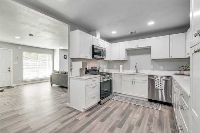 kitchen with sink, white cabinetry, and stainless steel appliances