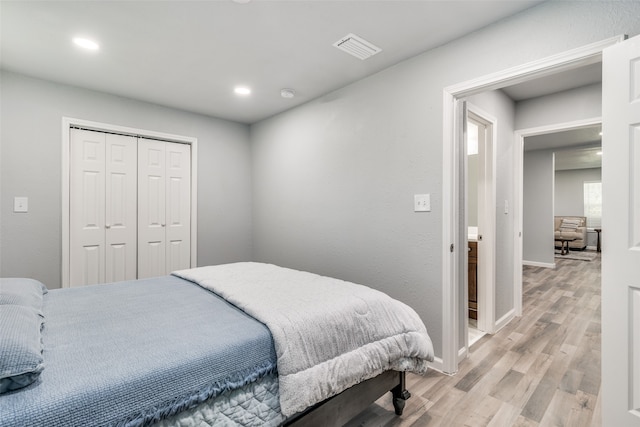 bedroom with light wood-type flooring and a closet