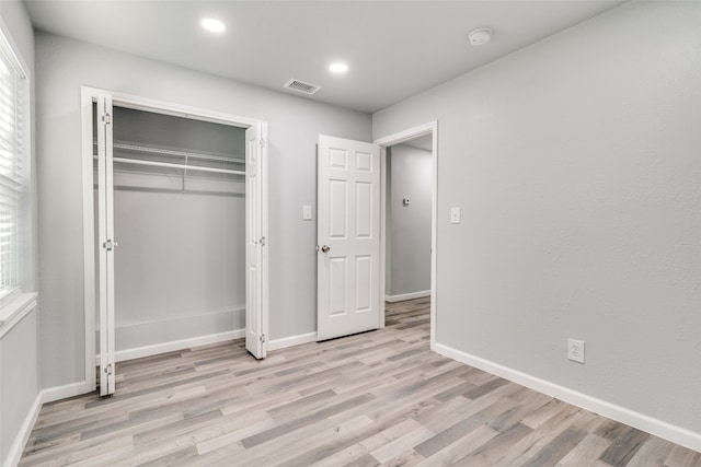 unfurnished bedroom featuring light hardwood / wood-style floors and a closet