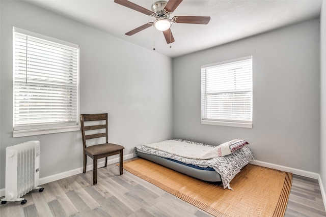 bedroom featuring radiator, ceiling fan, and light wood-type flooring