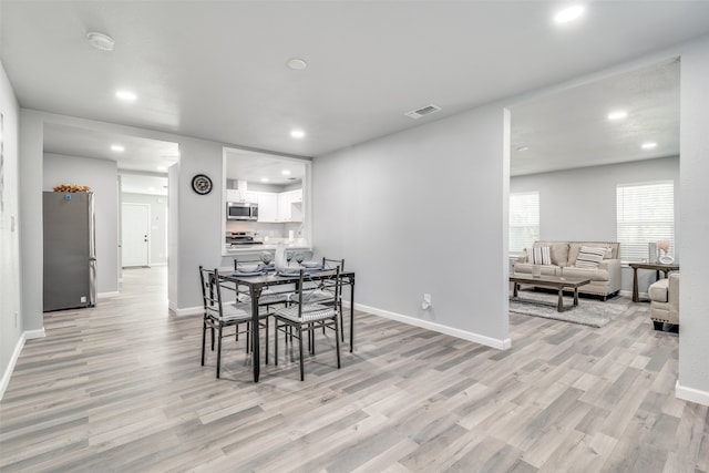 dining space with light hardwood / wood-style flooring