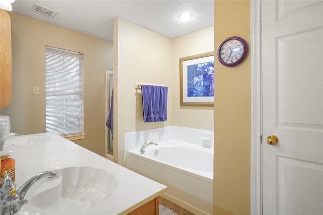 bathroom featuring vanity, a textured ceiling, and independent shower and bath