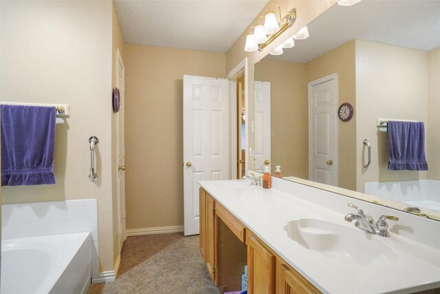 bathroom featuring tile patterned flooring, vanity, a textured ceiling, and a tub