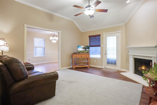 living room with crown molding, ceiling fan with notable chandelier, vaulted ceiling, and hardwood / wood-style flooring