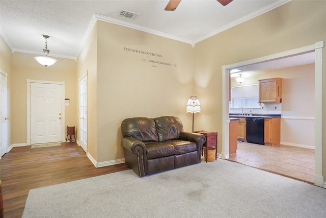 sitting room with ceiling fan, sink, crown molding, a textured ceiling, and light wood-type flooring