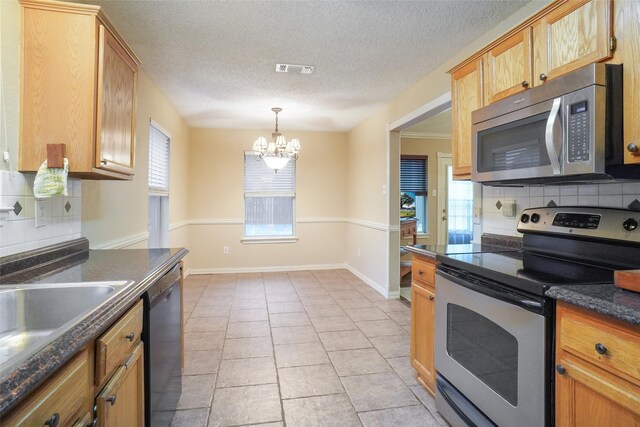 kitchen with plenty of natural light, a chandelier, appliances with stainless steel finishes, and tasteful backsplash