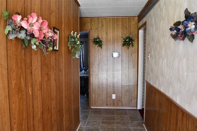 corridor with dark tile patterned flooring and wood walls