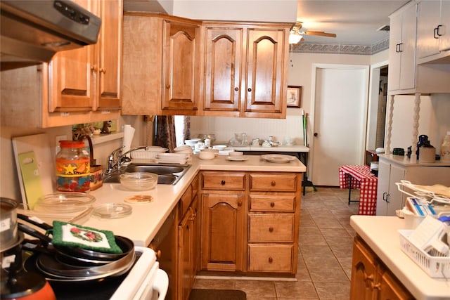 kitchen featuring sink, range, dark tile patterned floors, ceiling fan, and exhaust hood