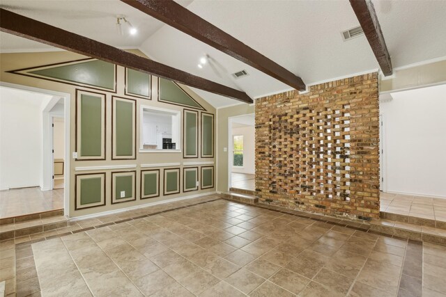 unfurnished living room with tile patterned floors, lofted ceiling with beams, and brick wall