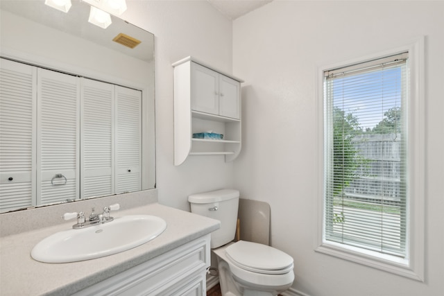 bathroom with vanity, toilet, and plenty of natural light