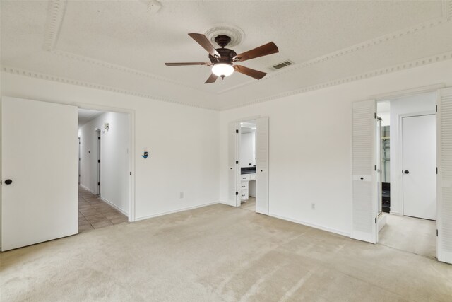 spare room featuring a textured ceiling, light colored carpet, and ceiling fan