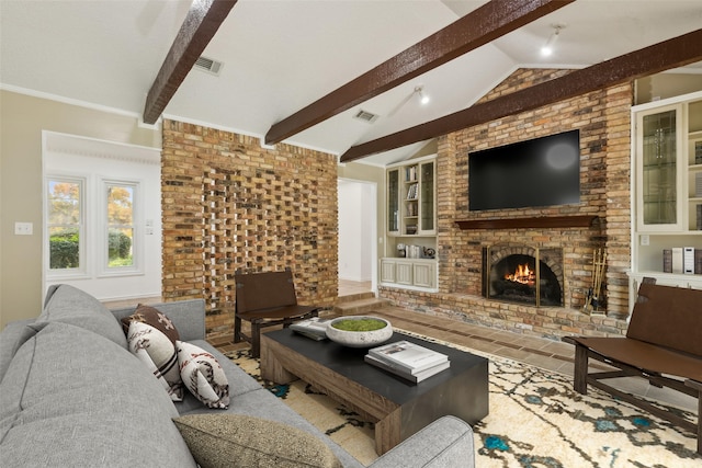 living room with vaulted ceiling with beams, built in features, and a brick fireplace