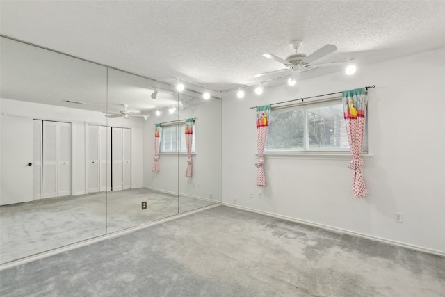 carpeted spare room with ceiling fan and a textured ceiling