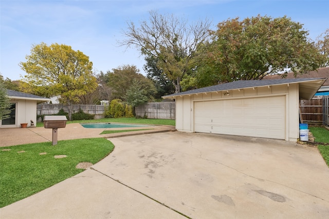 view of yard with a patio area, a garage, and a fenced in pool