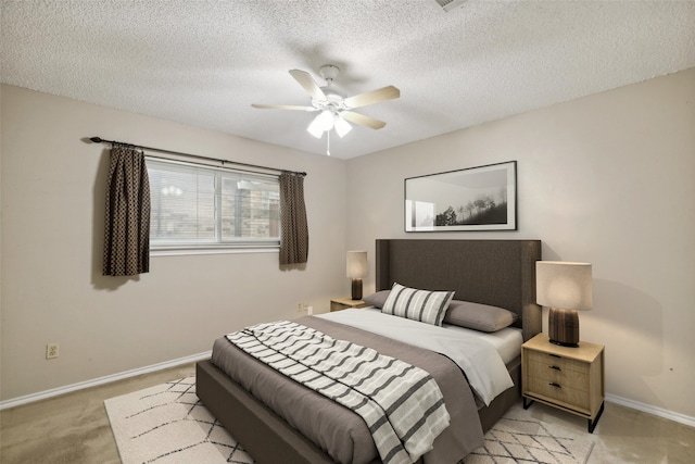 bedroom featuring ceiling fan, light colored carpet, and a textured ceiling