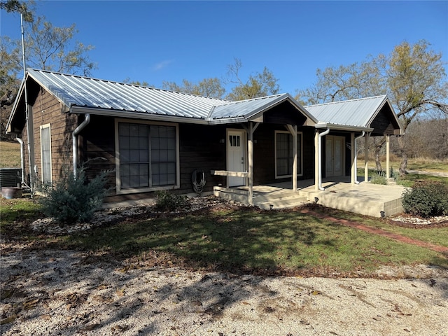 ranch-style home featuring covered porch, central AC, and a front yard