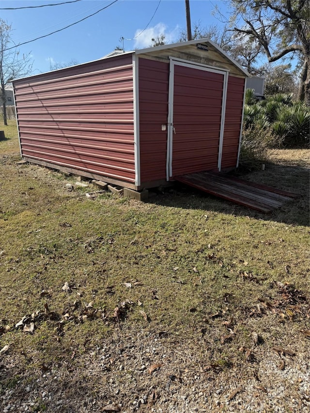 view of outbuilding featuring a lawn