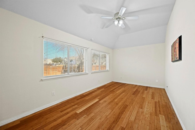 spare room featuring light wood-type flooring, vaulted ceiling, and ceiling fan