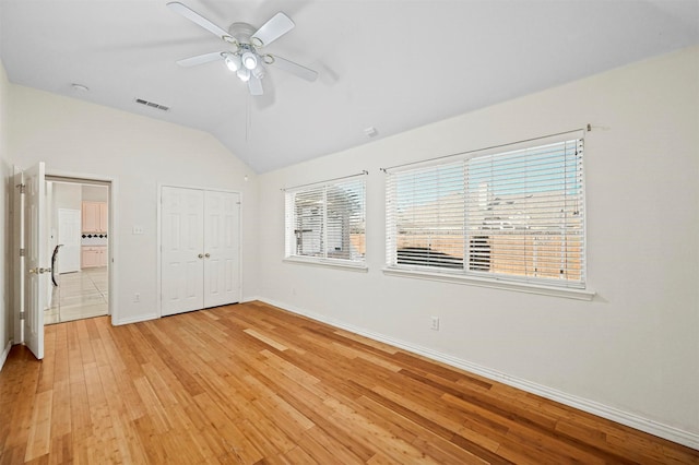 unfurnished bedroom with ceiling fan, light hardwood / wood-style floors, and lofted ceiling