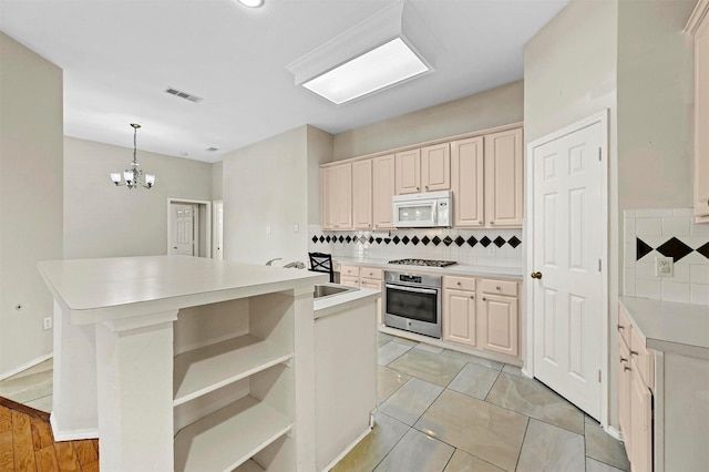 kitchen featuring sink, hanging light fixtures, tasteful backsplash, a kitchen island, and stainless steel appliances