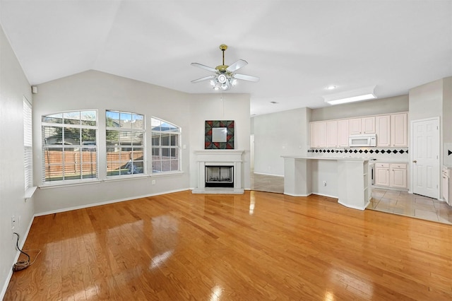 unfurnished living room with light hardwood / wood-style flooring, ceiling fan, and lofted ceiling