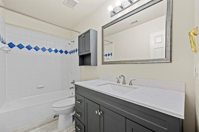 full bathroom with vanity, wood-type flooring, tiled shower / bath combo, and toilet