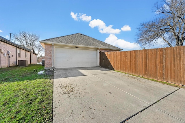 garage with central air condition unit and a lawn