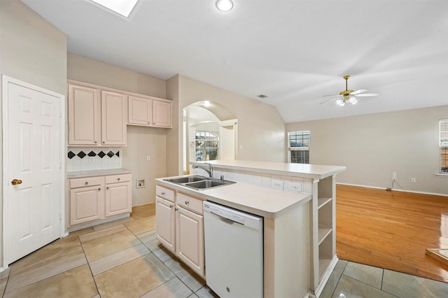 kitchen with dishwasher, a center island with sink, sink, ceiling fan, and decorative backsplash