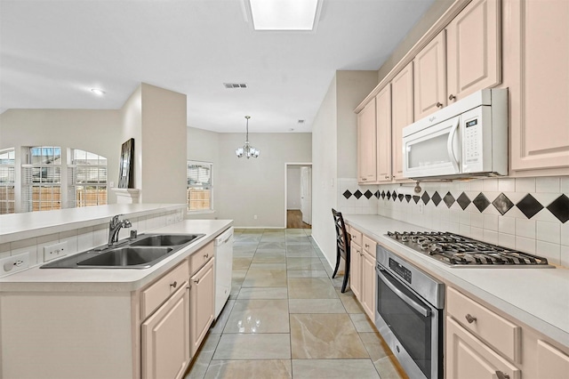 kitchen with sink, tasteful backsplash, a chandelier, decorative light fixtures, and appliances with stainless steel finishes