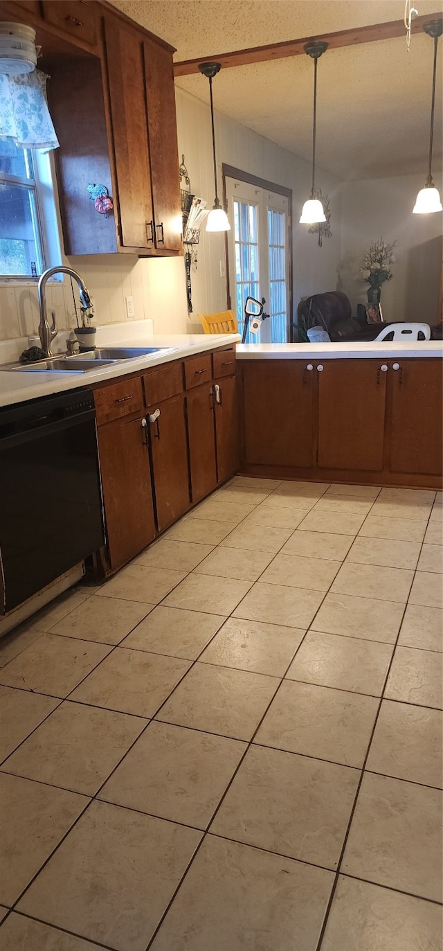 kitchen featuring dishwasher, a textured ceiling, hanging light fixtures, and sink