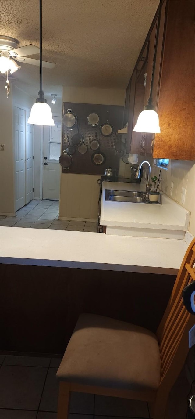 kitchen featuring light tile patterned flooring, sink, and a textured ceiling