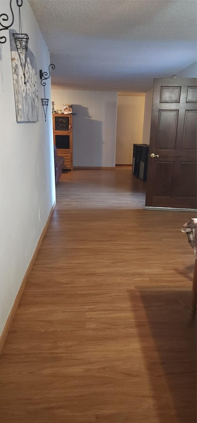 hallway featuring hardwood / wood-style flooring and a textured ceiling