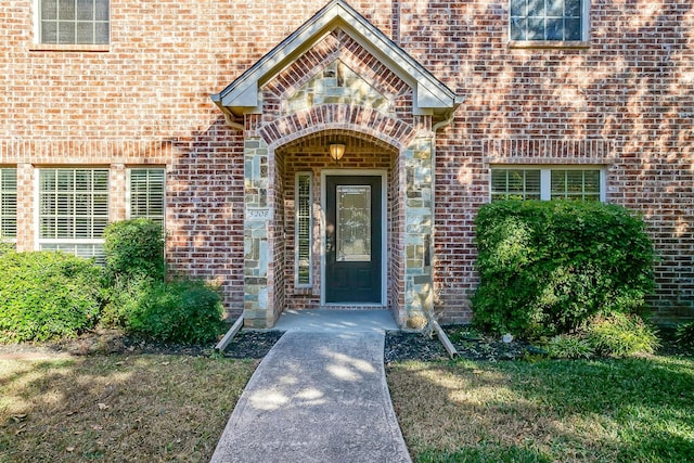 view of exterior entry with a yard