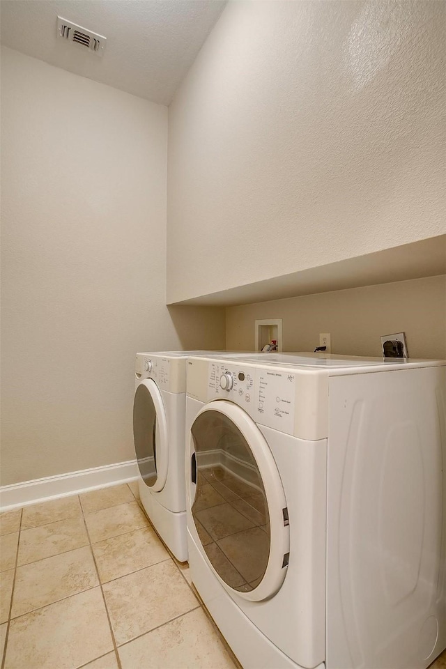 laundry room featuring independent washer and dryer and light tile patterned floors