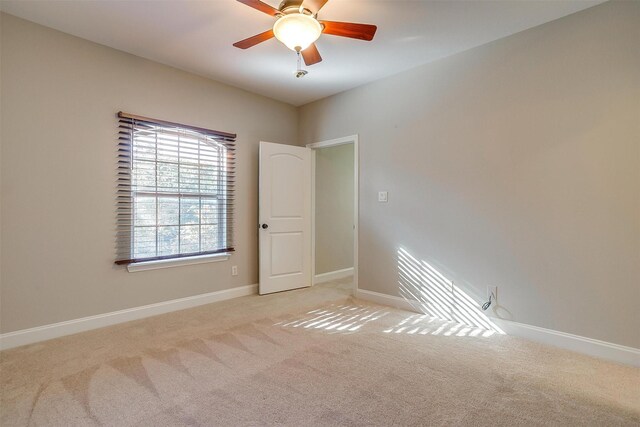 carpeted spare room featuring ceiling fan