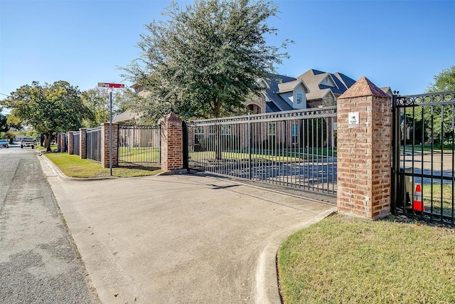 view of gate with a lawn