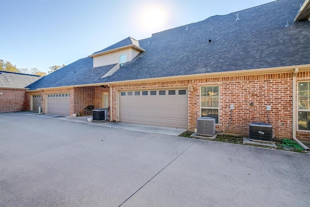 view of front of property featuring cooling unit and a garage