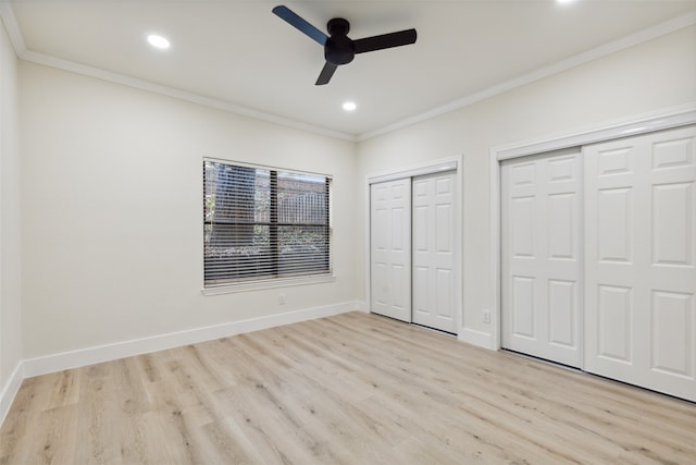 unfurnished bedroom with ornamental molding, light wood-type flooring, ceiling fan, and multiple closets