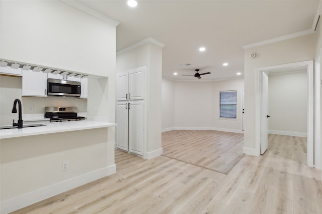 kitchen featuring white cabinets, sink, light hardwood / wood-style flooring, ceiling fan, and stainless steel appliances