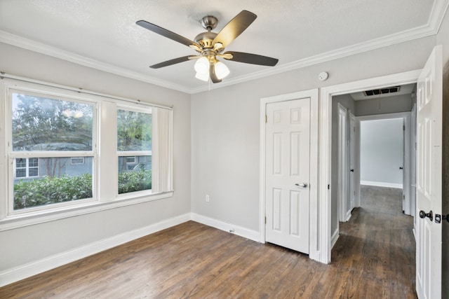 unfurnished bedroom with ornamental molding, a textured ceiling, ceiling fan, dark hardwood / wood-style floors, and a closet