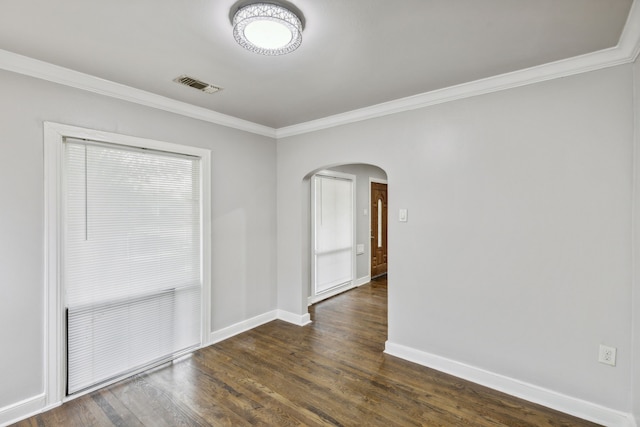 empty room featuring dark hardwood / wood-style flooring and ornamental molding