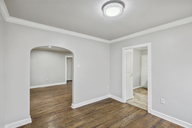 spare room featuring crown molding and dark wood-type flooring