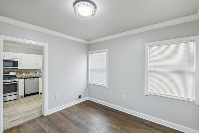 spare room featuring hardwood / wood-style flooring and crown molding