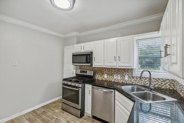 kitchen featuring sink, decorative backsplash, light wood-type flooring, appliances with stainless steel finishes, and white cabinetry